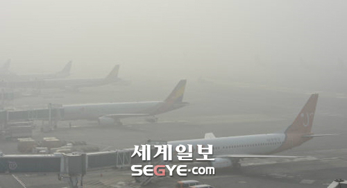 항공기 운항도 차질 짙은 안개와 중국발 미세먼지의 영향으로 우리나라 전역이 뿌옇게 변한 25일 김포공항 국내선 계류장에 운항 차질로 이륙을 기다리는 항공기들이 늘어서 있다.(사진)